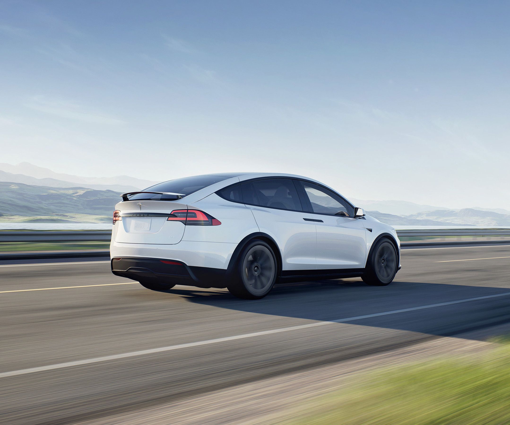 Model X bianco perla su una strada di montagna