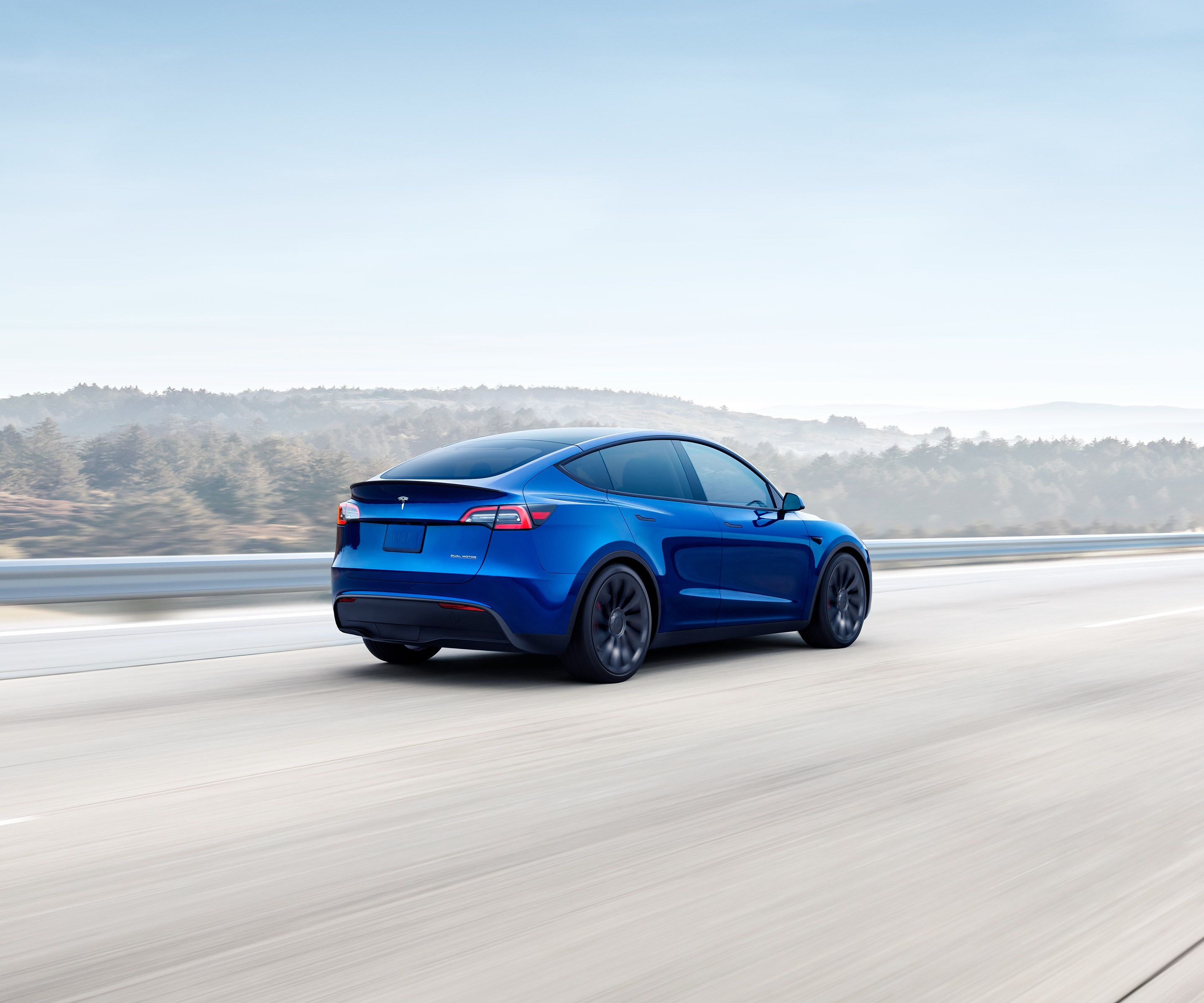 Model Y blu metallizzata su un'autostrada in collina